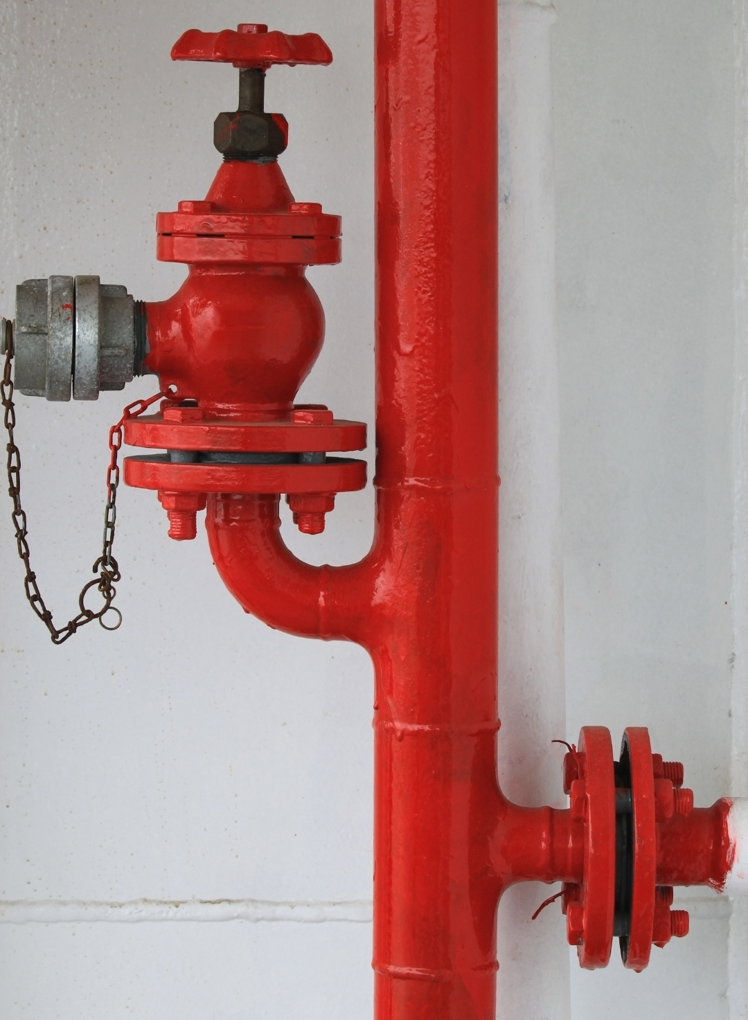 A red pipe with a valve attached to it