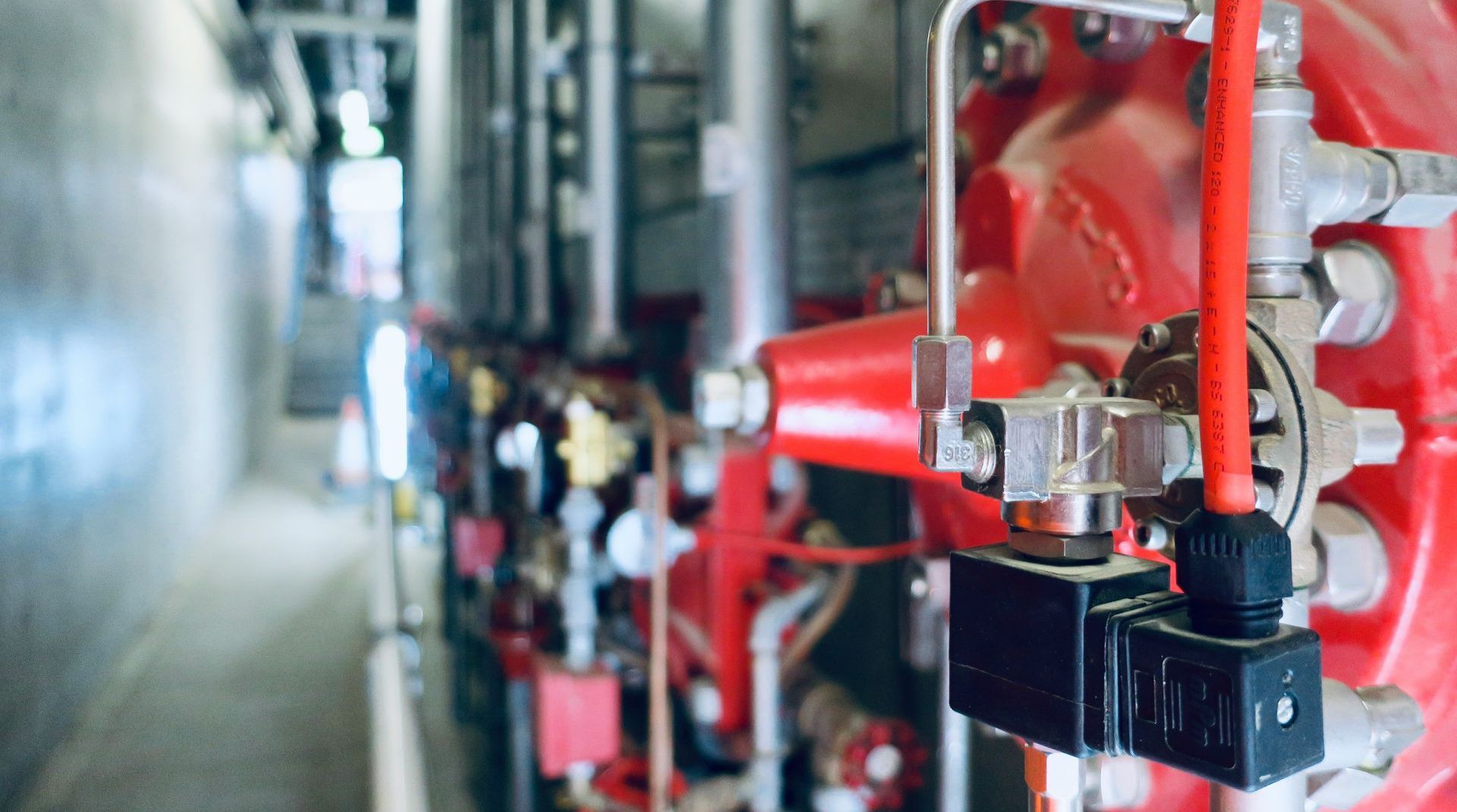 A close up of a machine in a factory with a lot of pipes and valves.