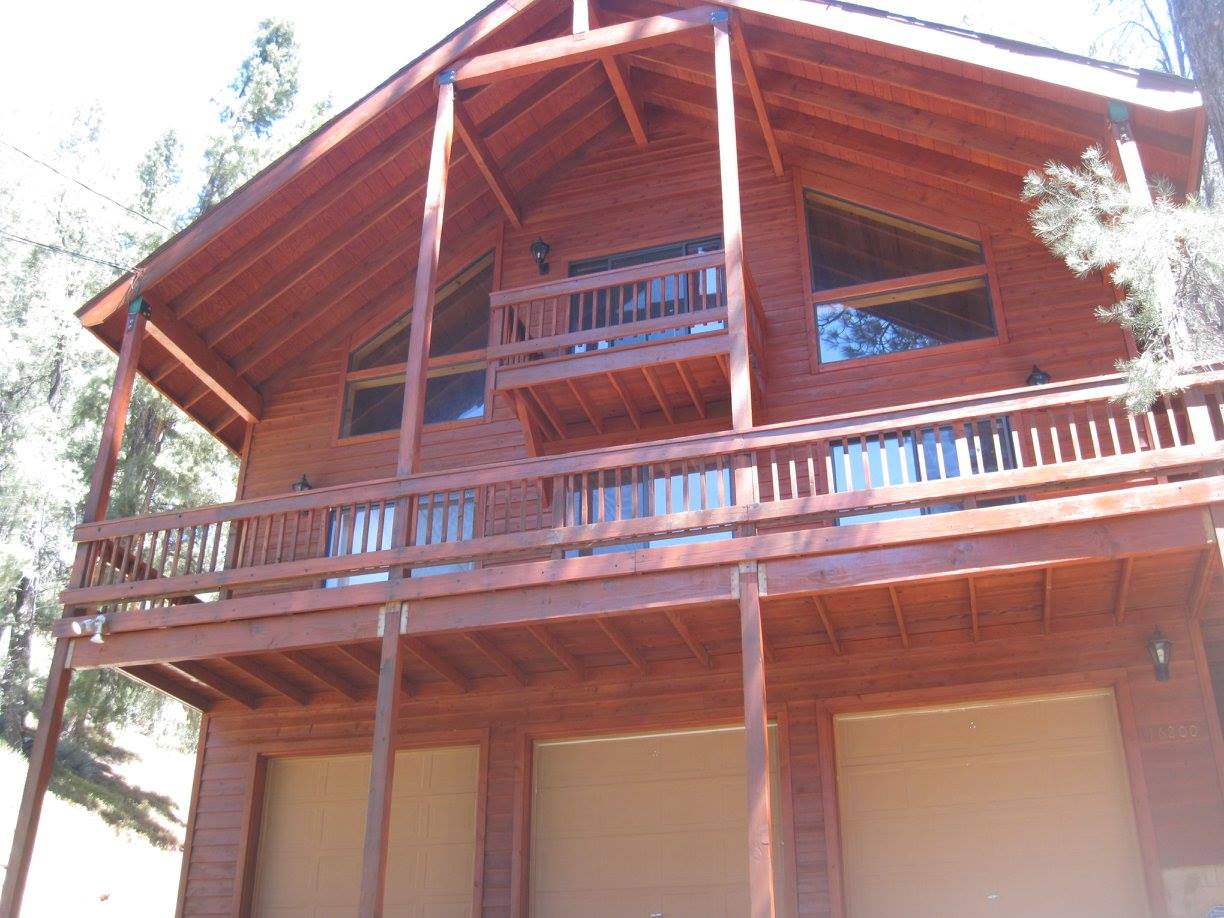 A large wooden house with a balcony on top of it