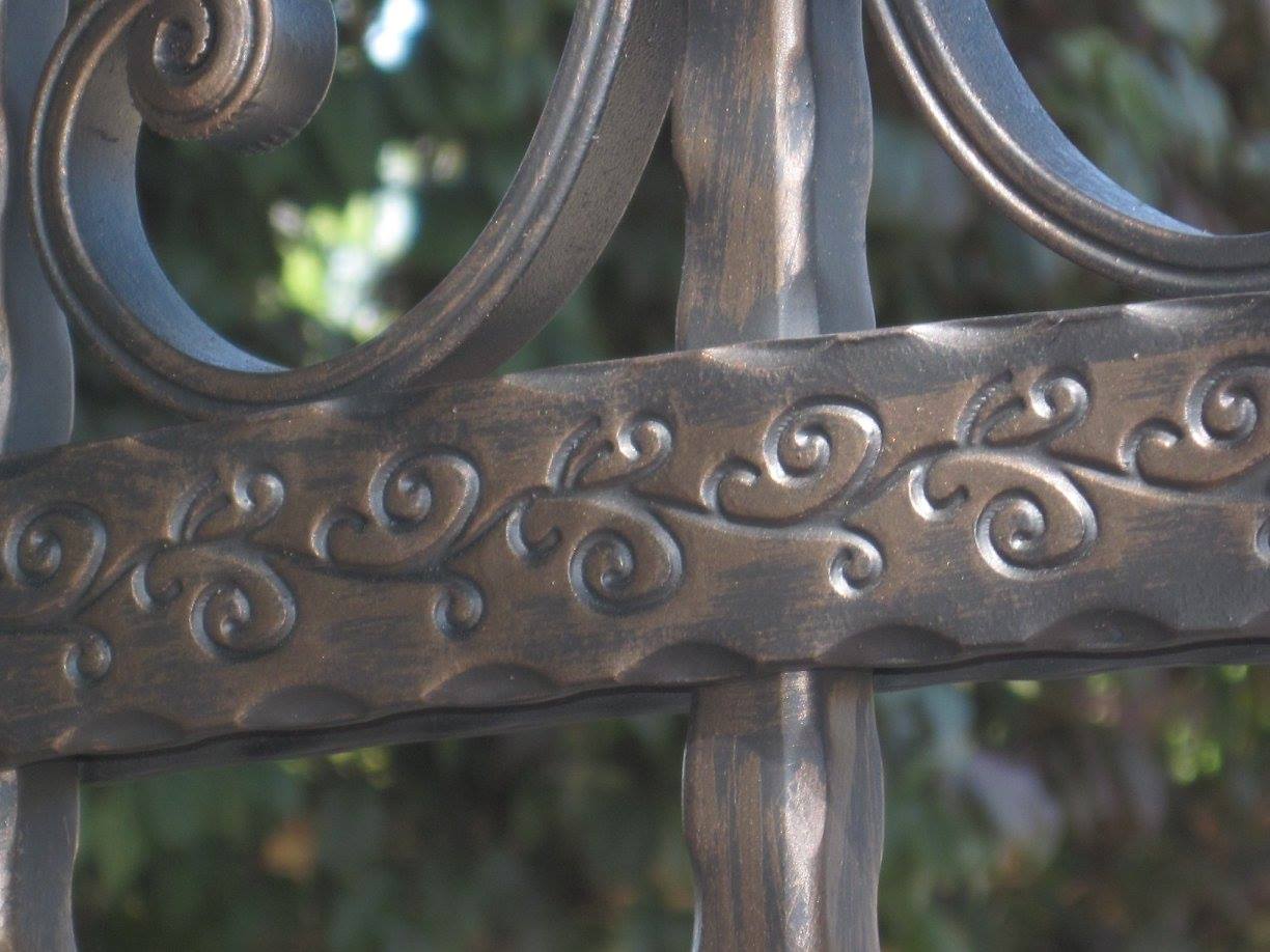 A close up of a wrought iron fence with swirls on it