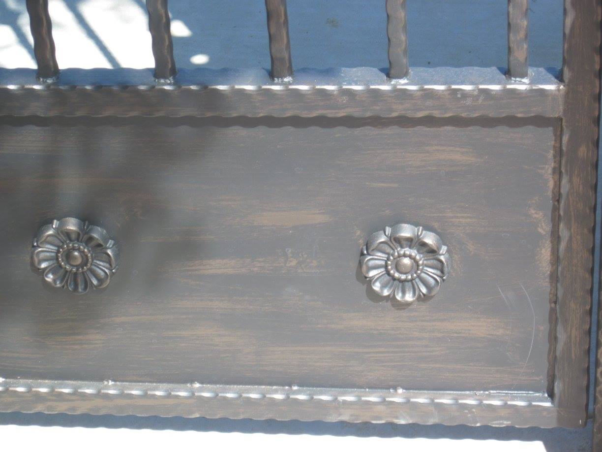A close up of a wrought iron gate with flowers on it