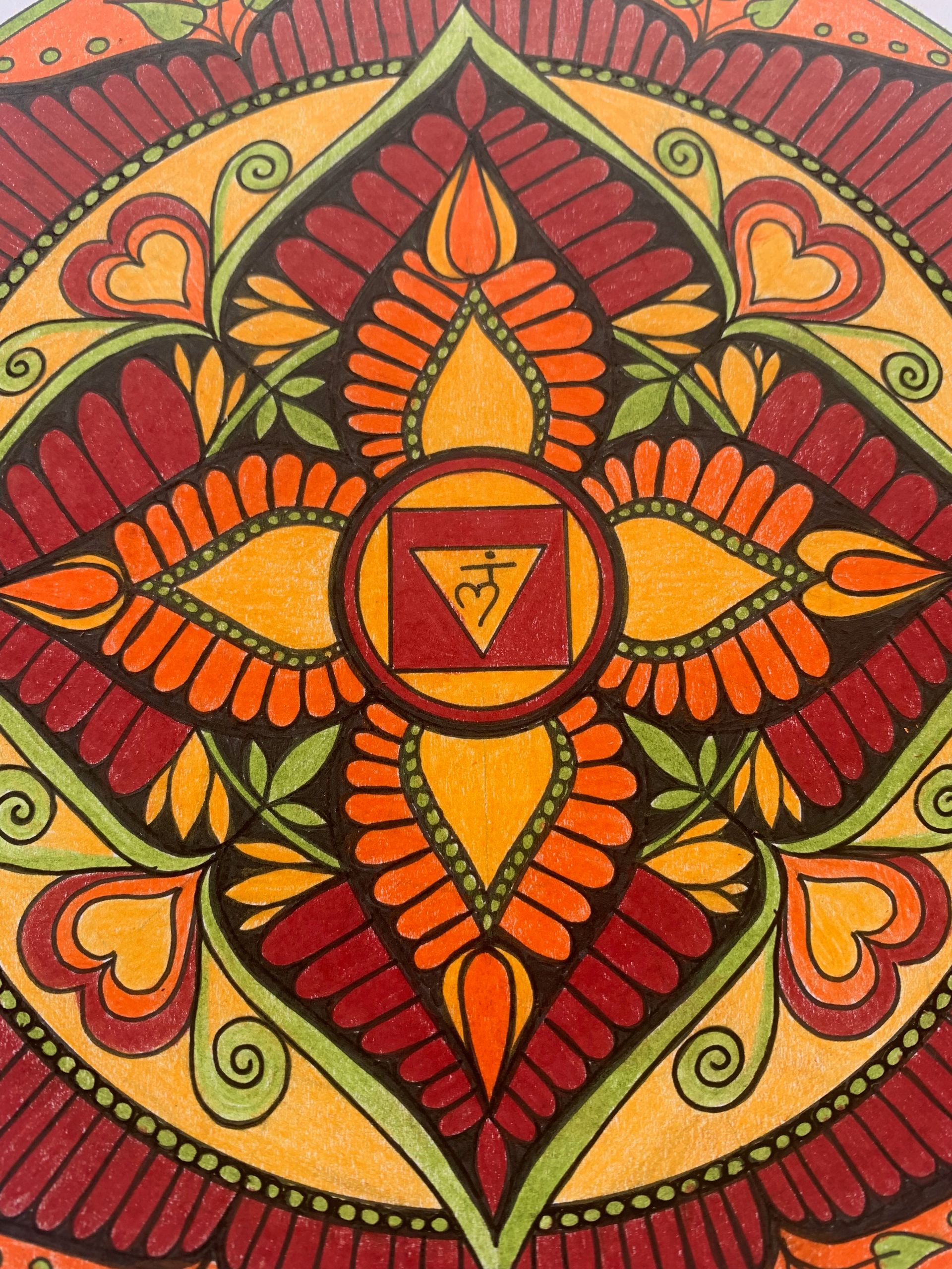 Colorful mandala with an orange and red floral pattern. A symbol is in the center.