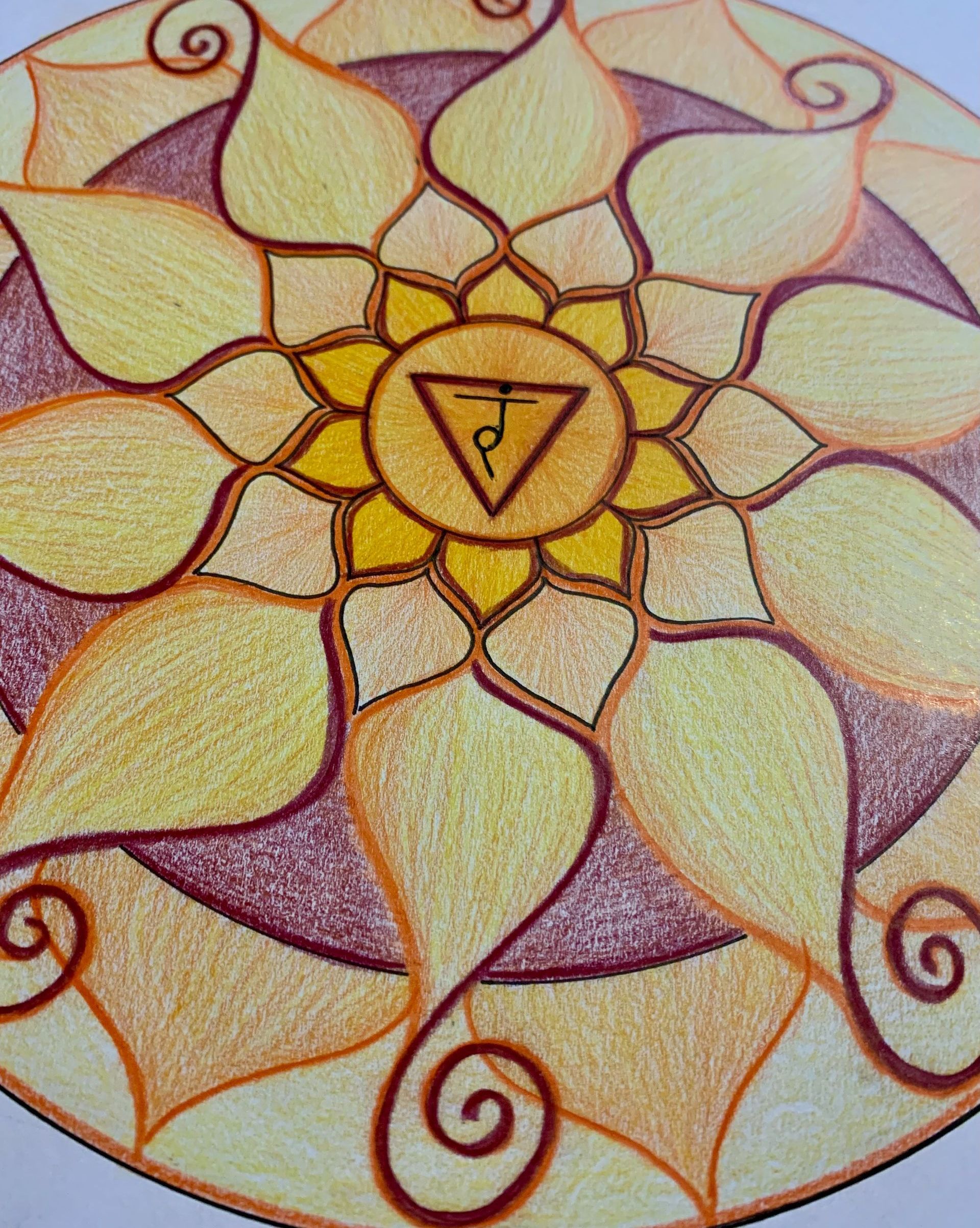 Yellow and purple mandala with a central triangle symbol.