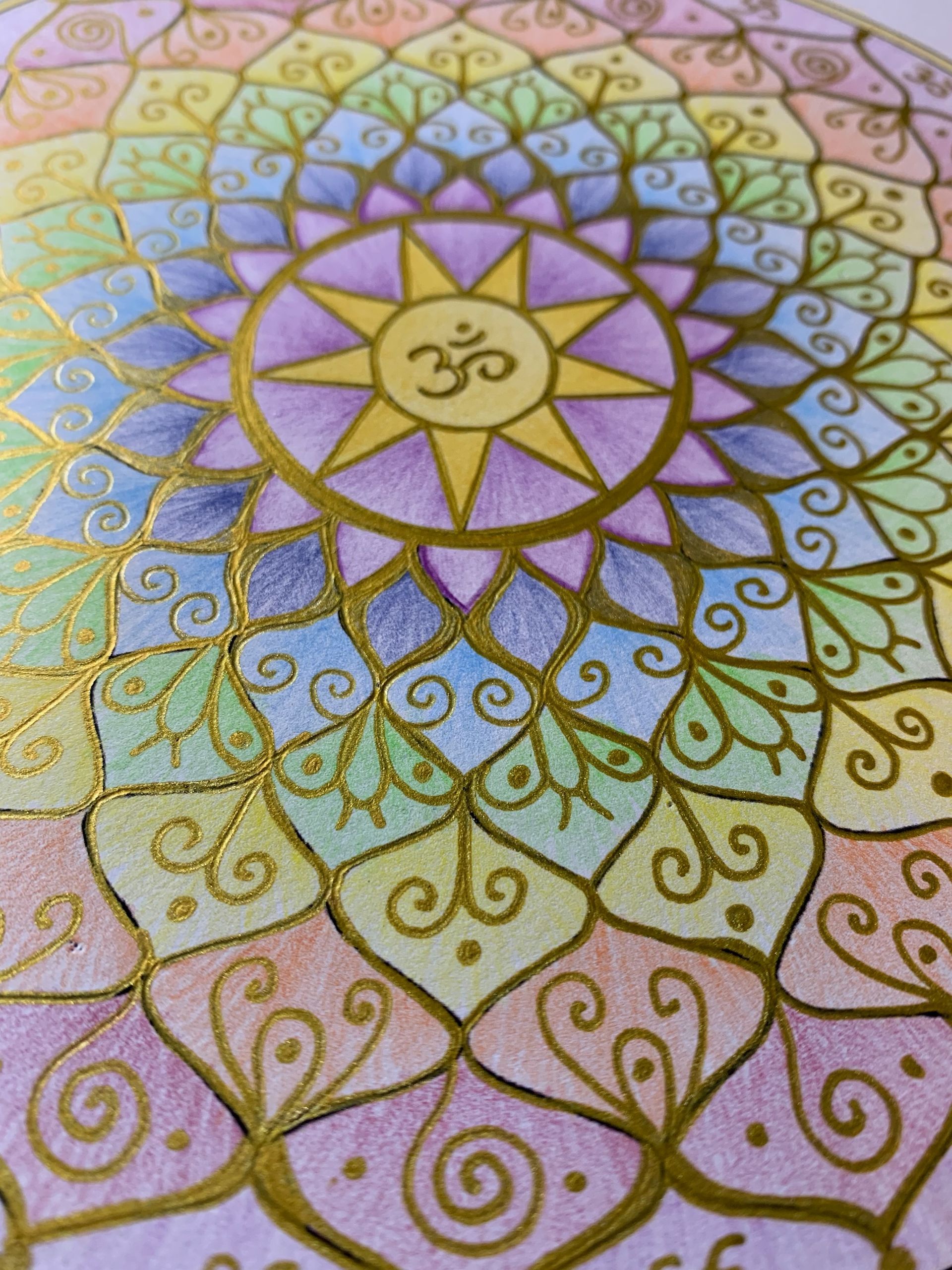 A colorful, hand-drawn circular mandala with a golden Om symbol in the center, featuring intricate patterns and outlines.
