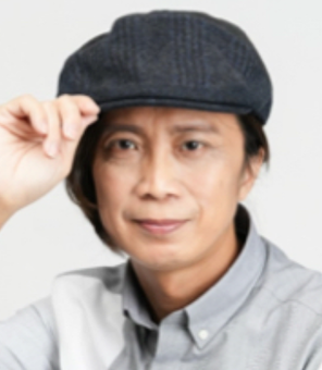 一名戴著帽子、身穿灰色襯衫的男子看著鏡頭