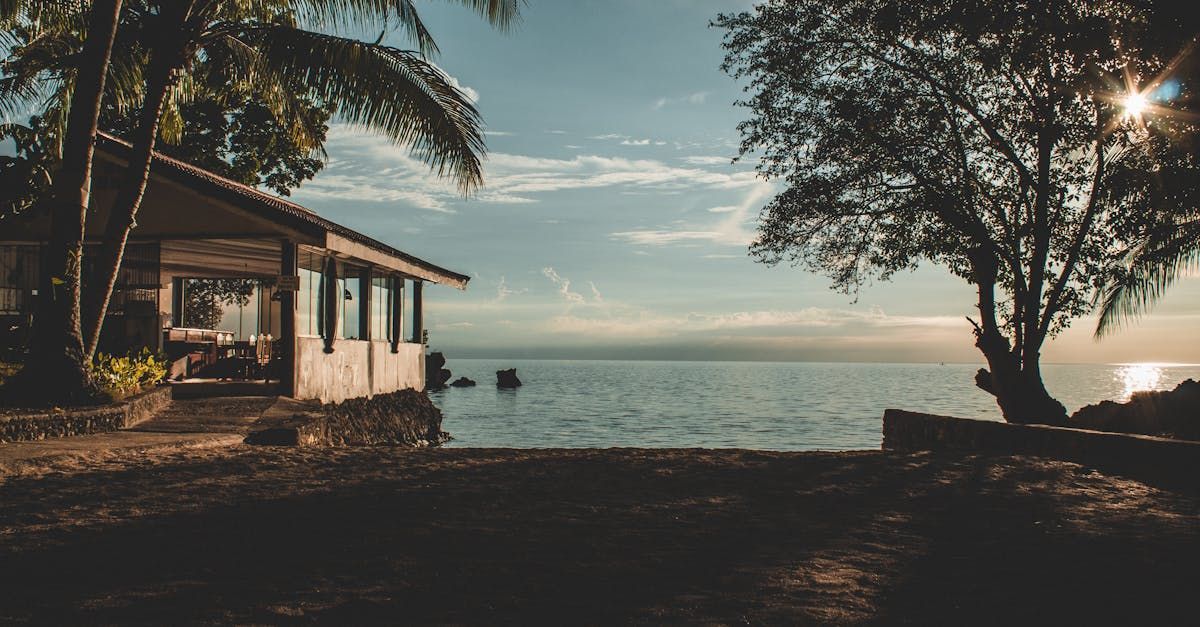 There is a house on the beach next to the ocean.