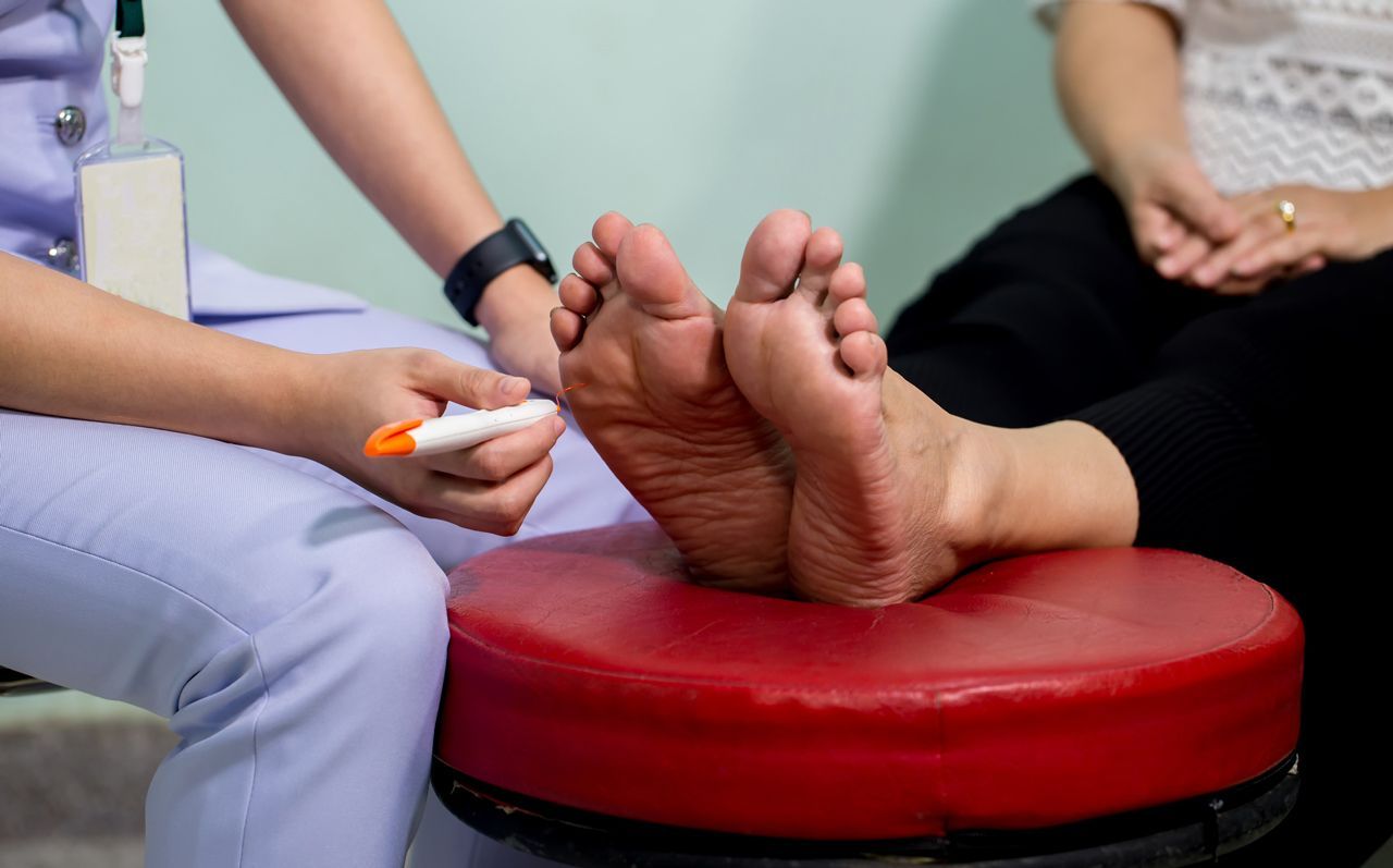 A nurse is writing on a patient 's feet with a marker.