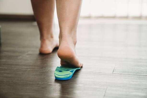 A person is walking barefoot on a wooden floor.