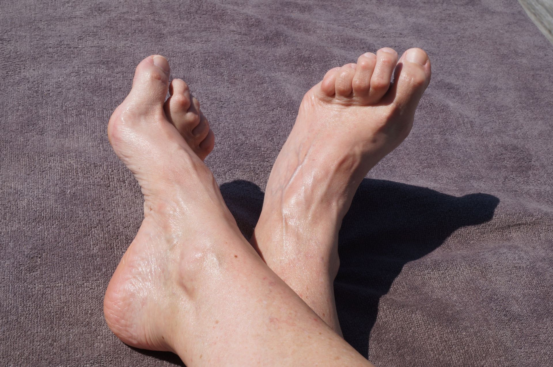 A close up of a person 's feet on a bed.