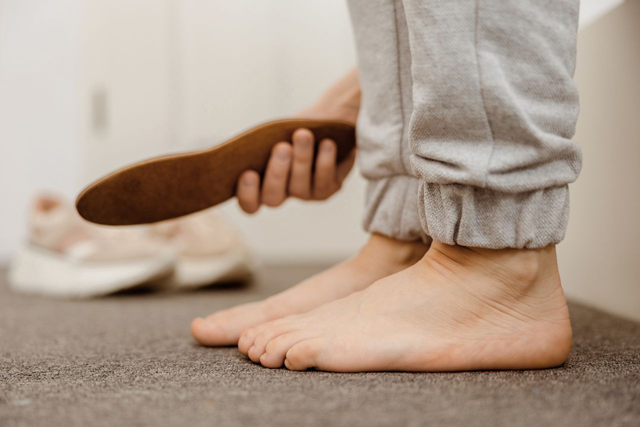 A person is holding a shoe insole in their hand.