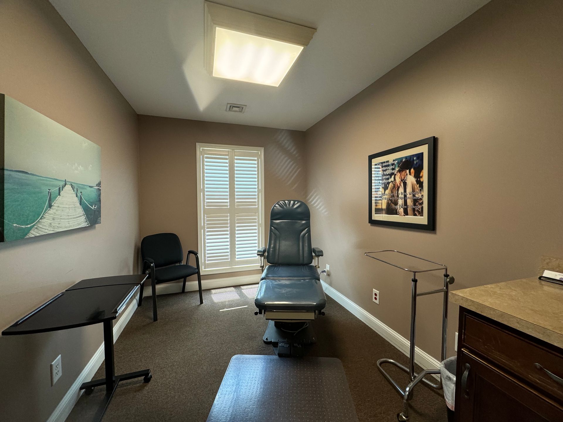 A person is holding their foot in their hands on a wooden floor.