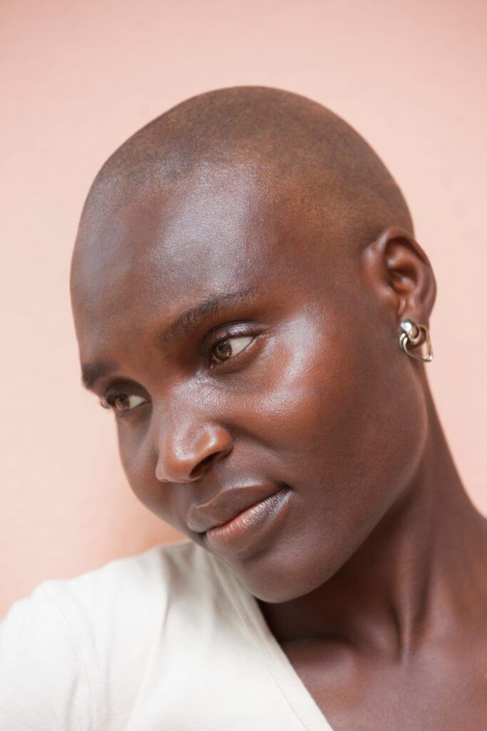 A close up of a woman 's face with a shaved head