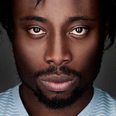 A close up of a man 's face with a beard.