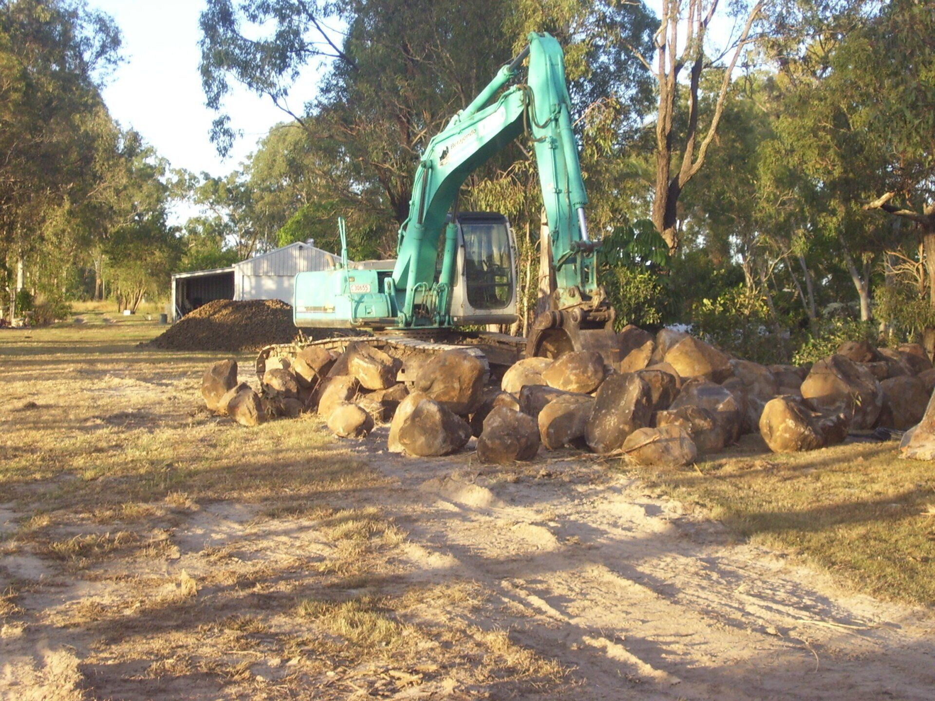 Excavator Placing Rocks for Rock Wall — A1 Rock This City Truck & Dog Hire In Good Night QLD