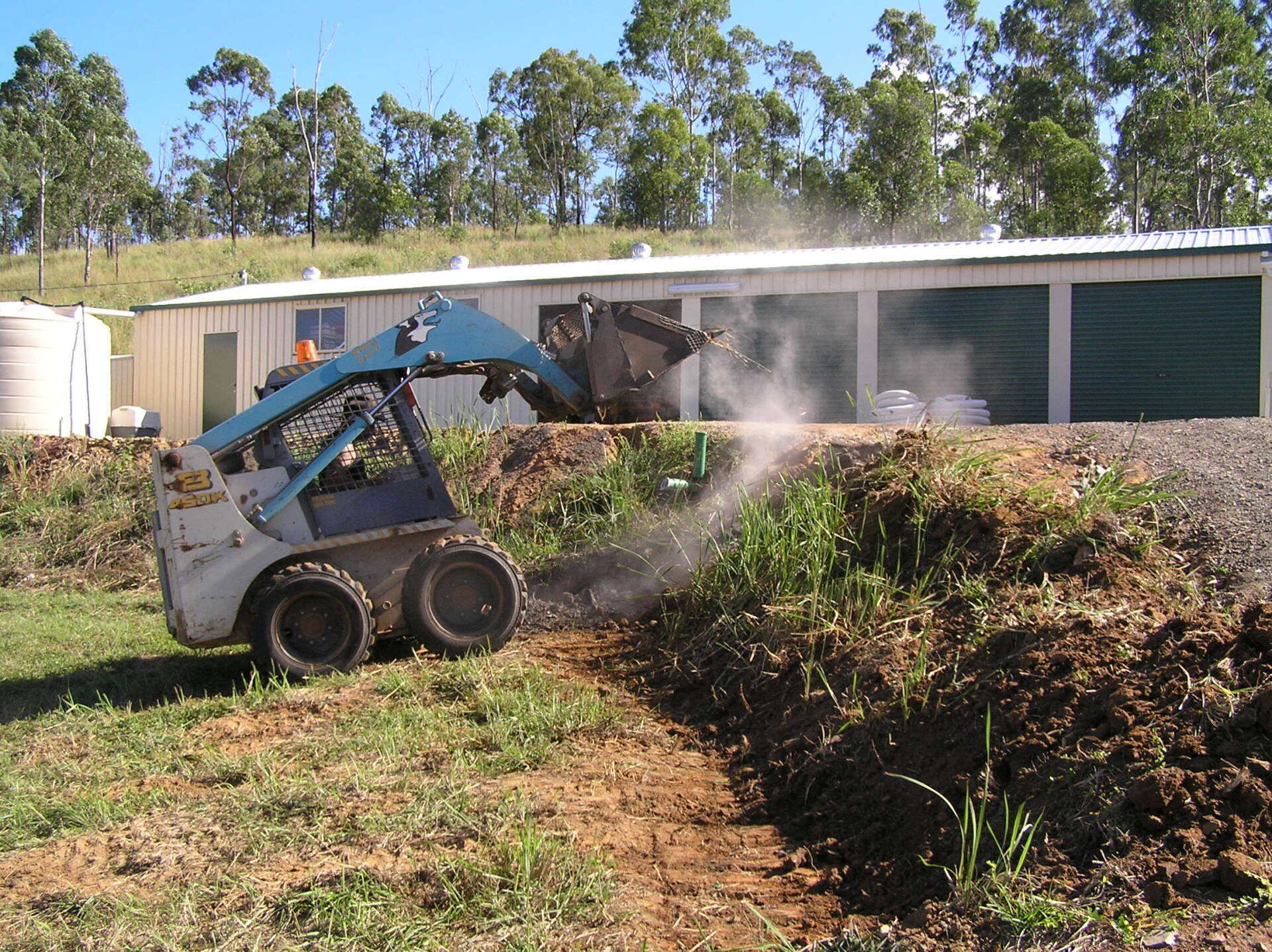 Bobcat Preparing Base for Rock Wall — A1 Rock This City Truck & Dog Hire In Good Night QLD