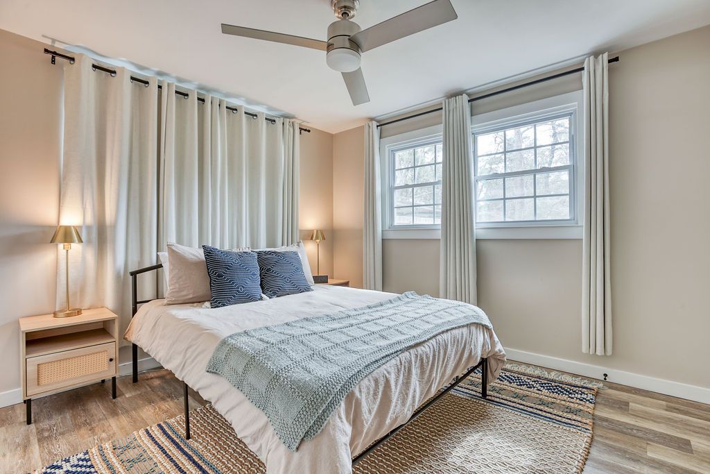 A bedroom with a bed and a ceiling fan.