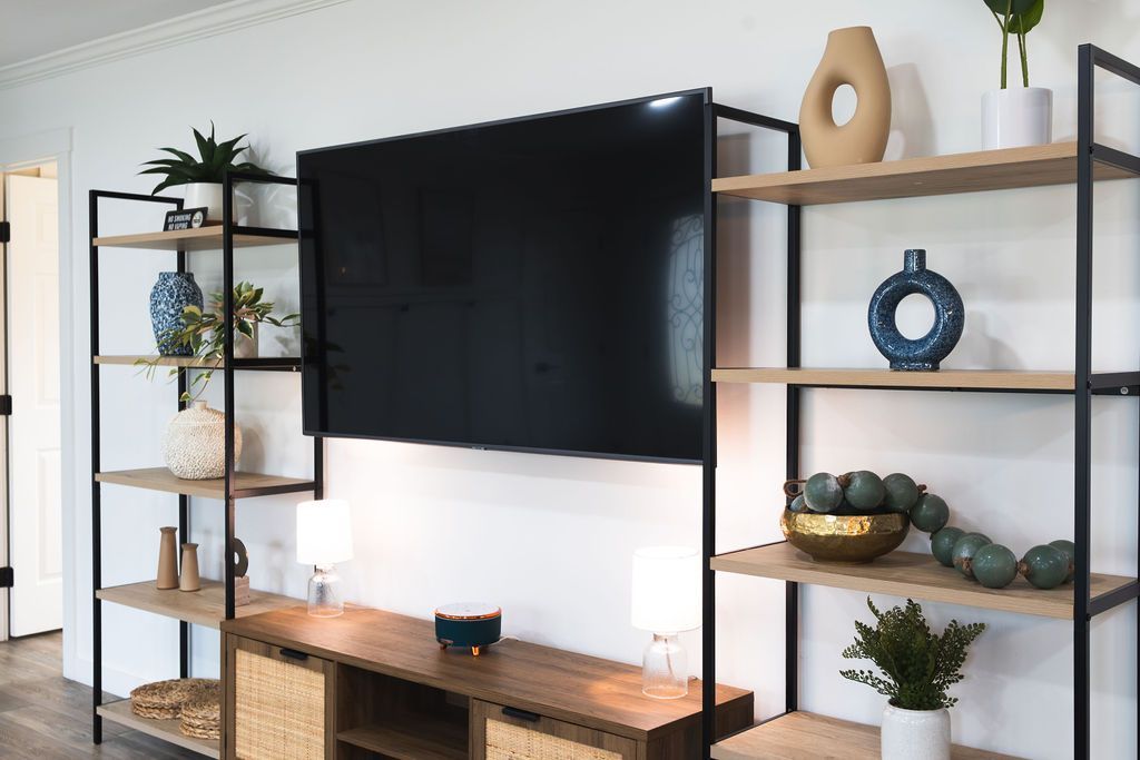 A living room with a flat screen tv hanging on the wall.