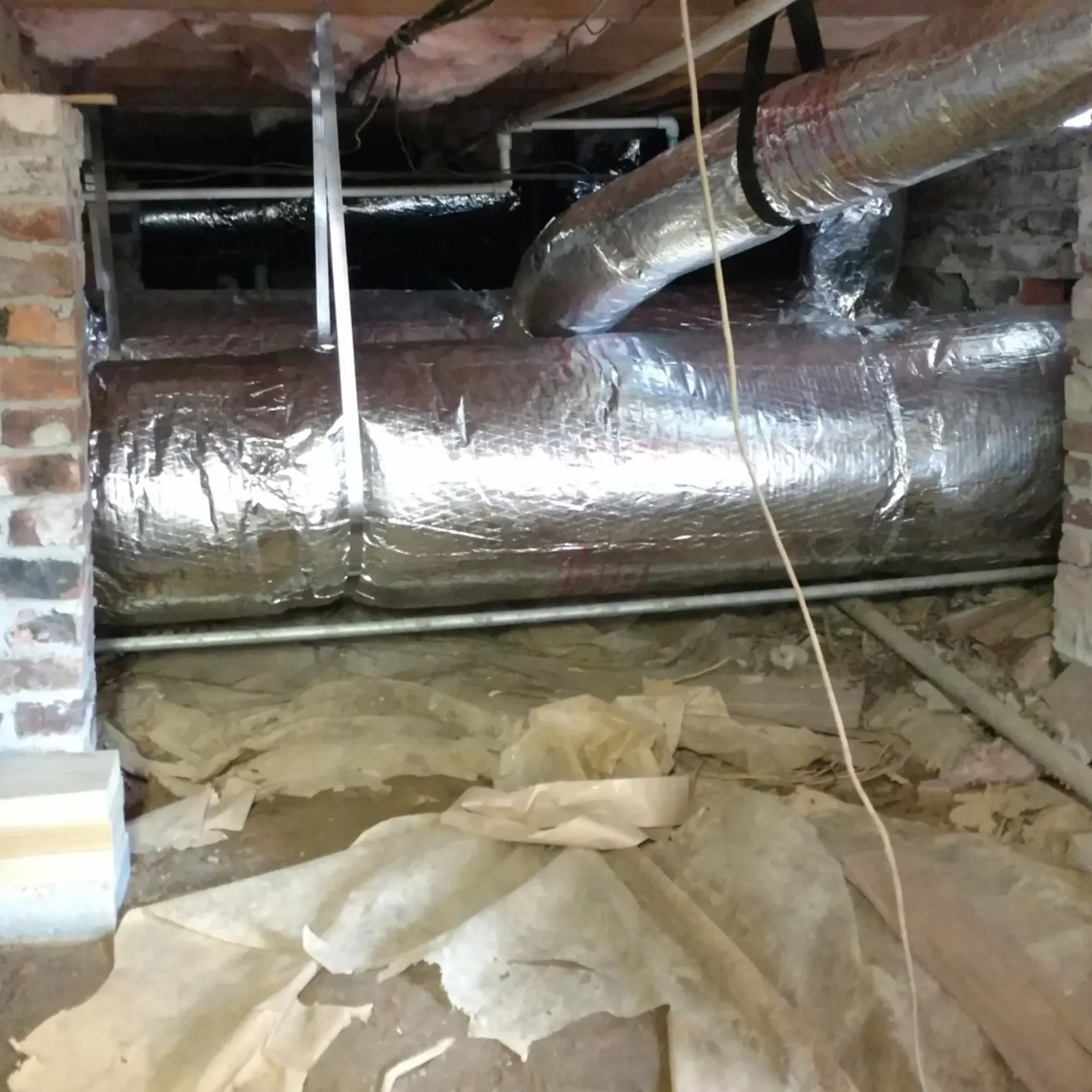 A bunch of pipes are wrapped in aluminum foil