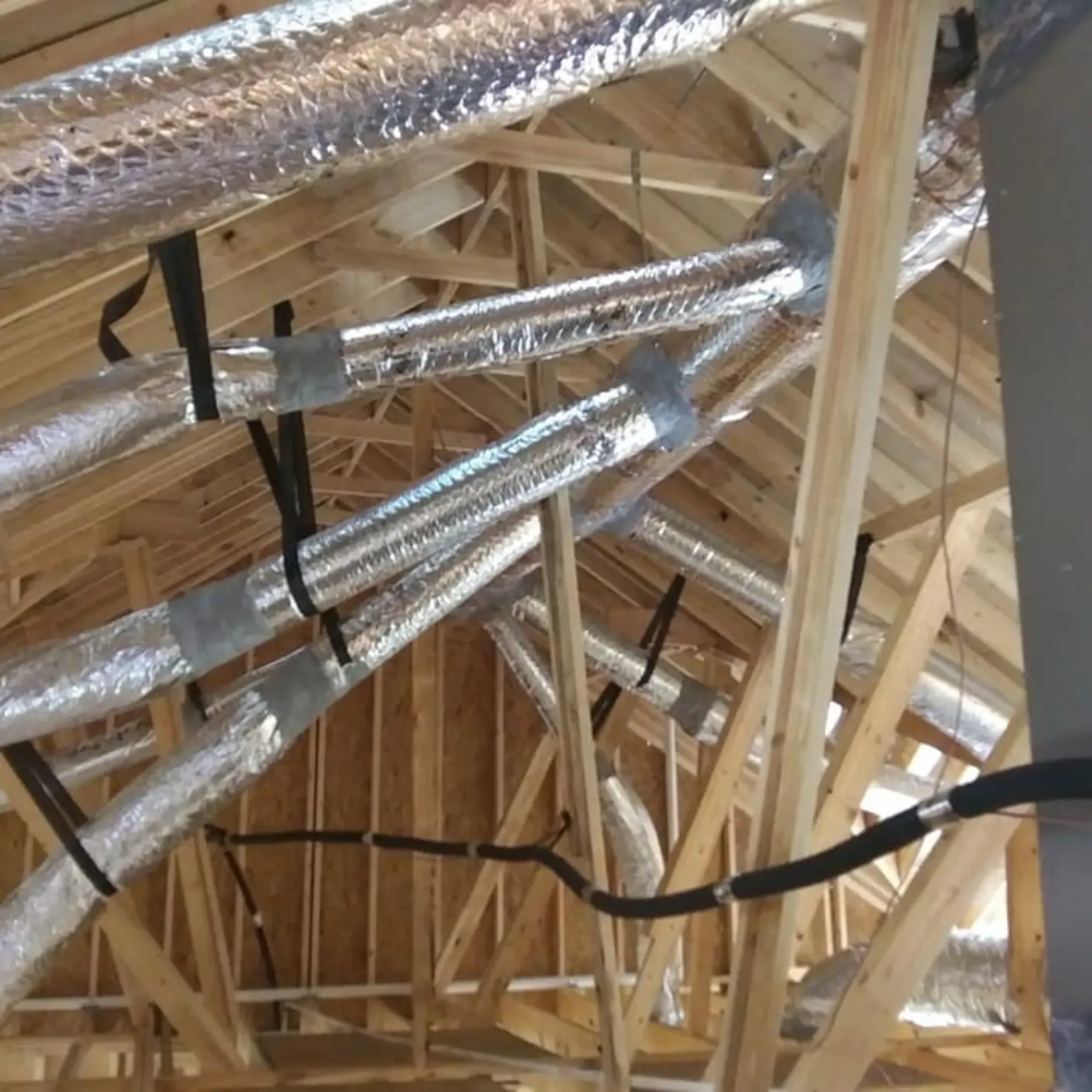 A ceiling with a lot of pipes and wires