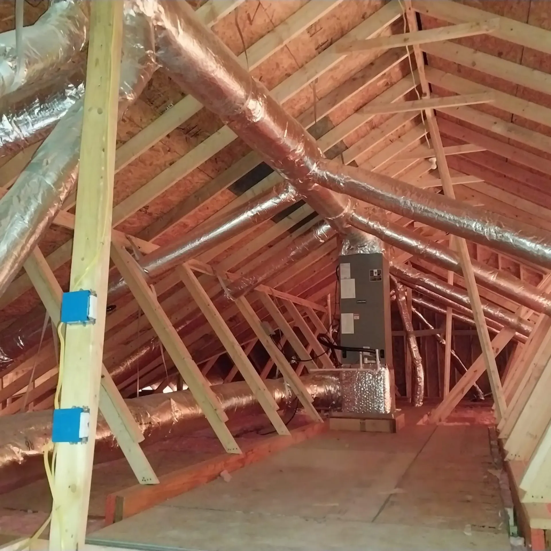The attic of a house under construction with copper pipes
