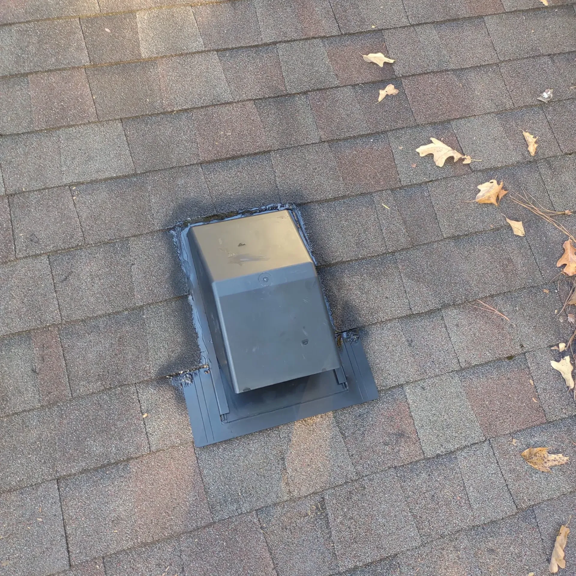 There is a vent on the roof of a house.