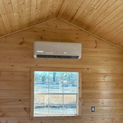A room with a window and a wall mounted air conditioner.