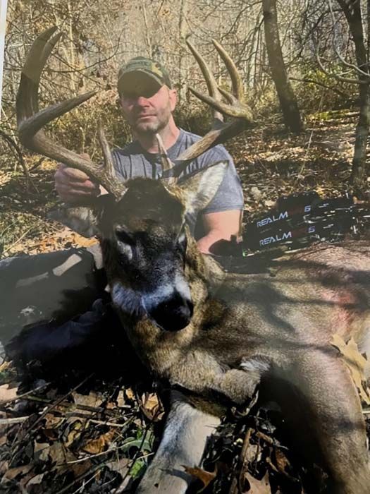 Hunter celebrating a successful deer harvest in the forest