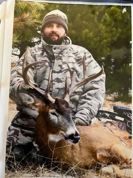 A proud hunter poses with a deer caught in the early morning