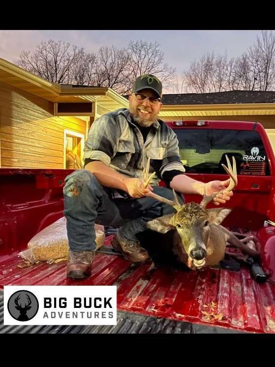 Triumphant hunter holding a deer by its antlers after a long hunt