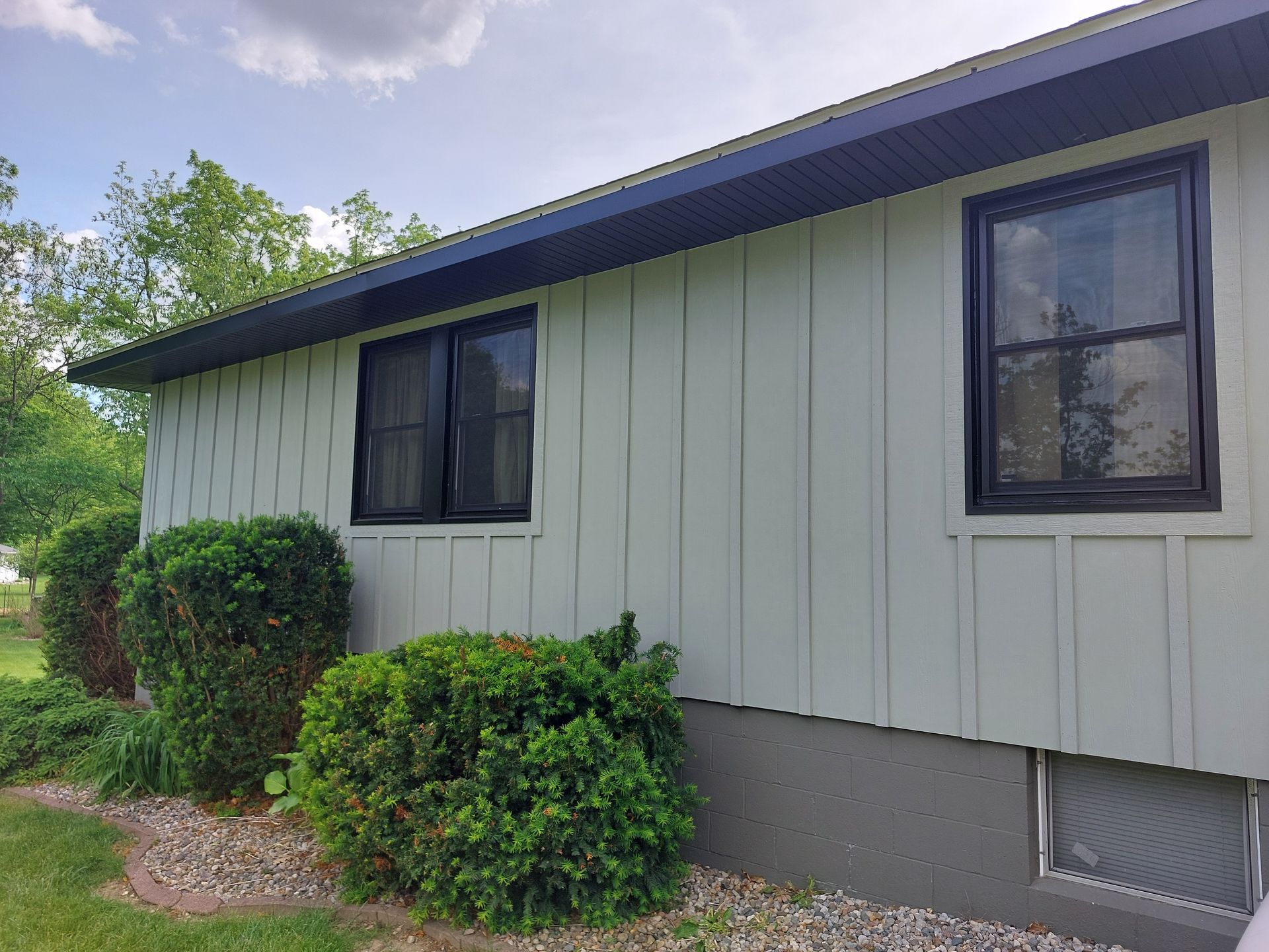 Beige vinyl siding partially installed on a house exterior with a ladder leaning against the wall.