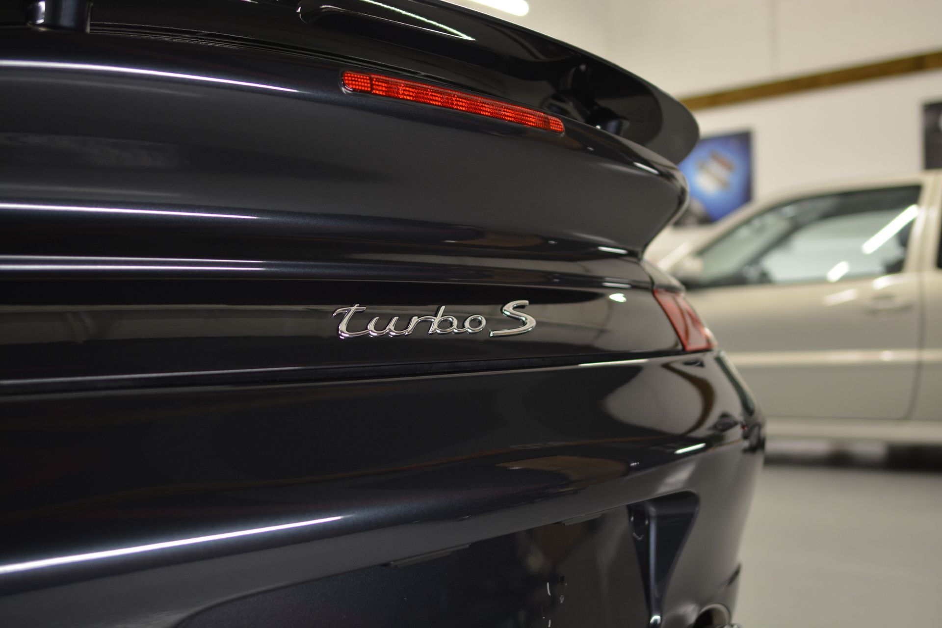 A black turbos car is parked in a garage