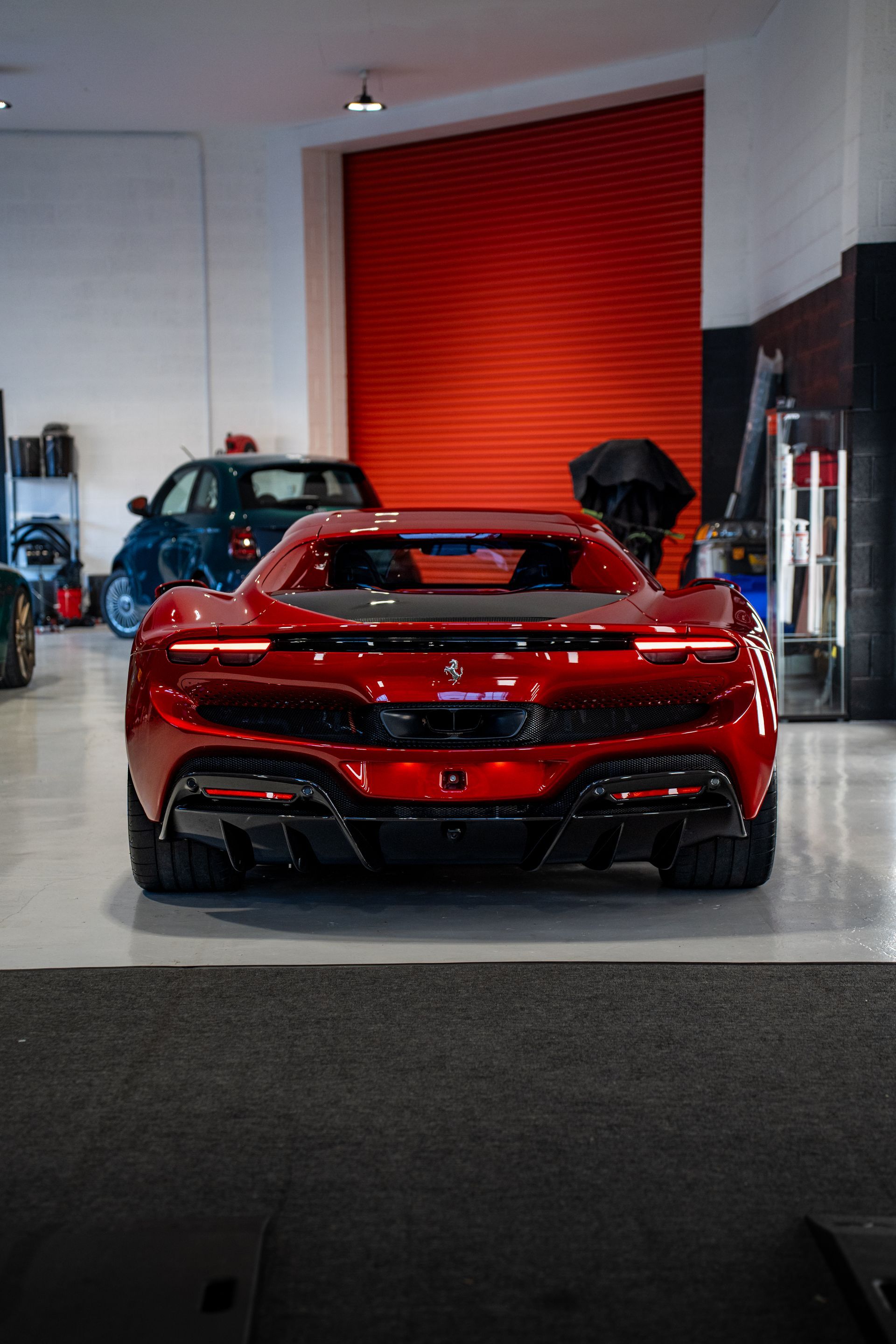 A red sports car is parked in a garage.