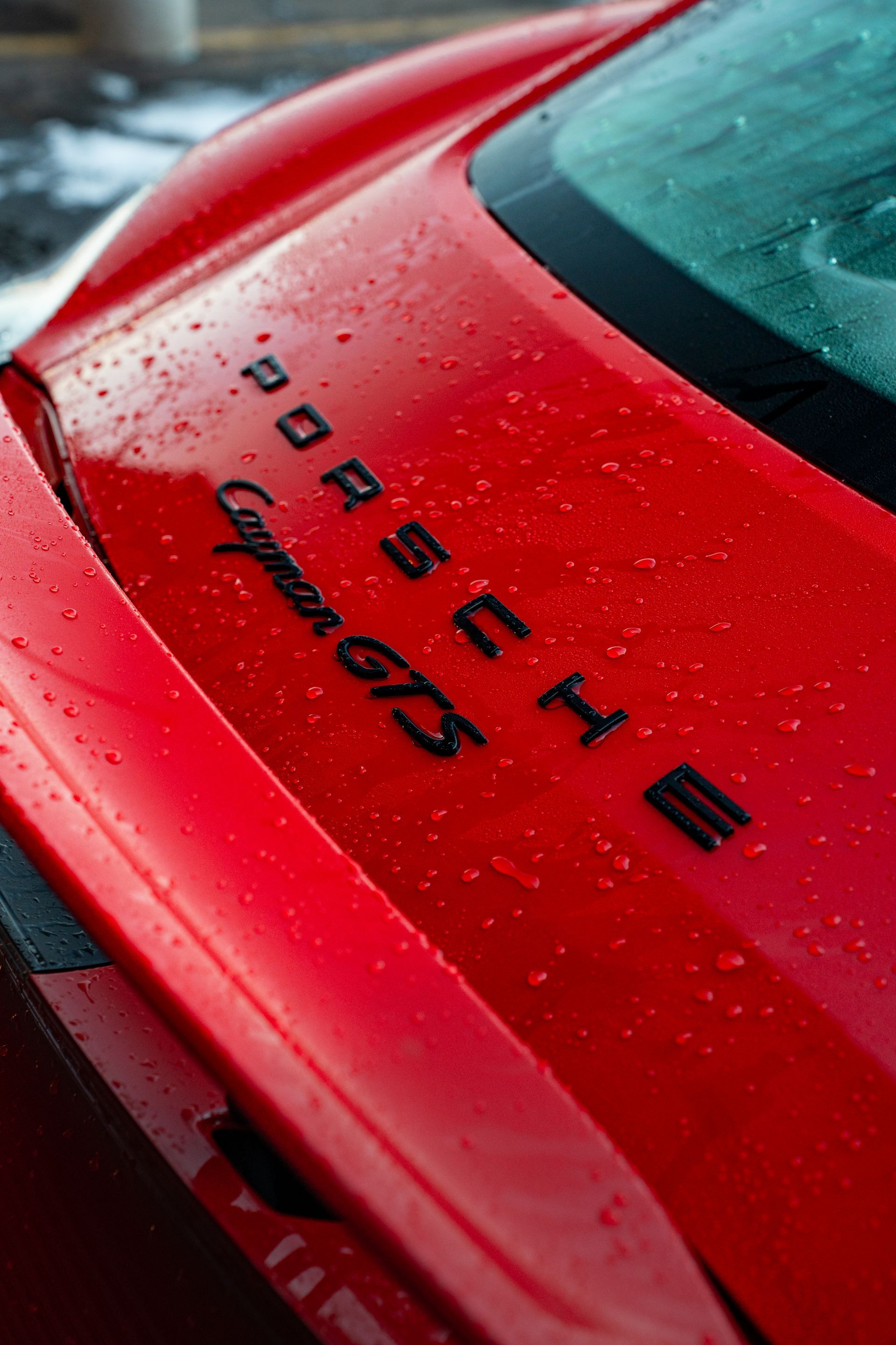 A close up of the hood of a red porsche car.