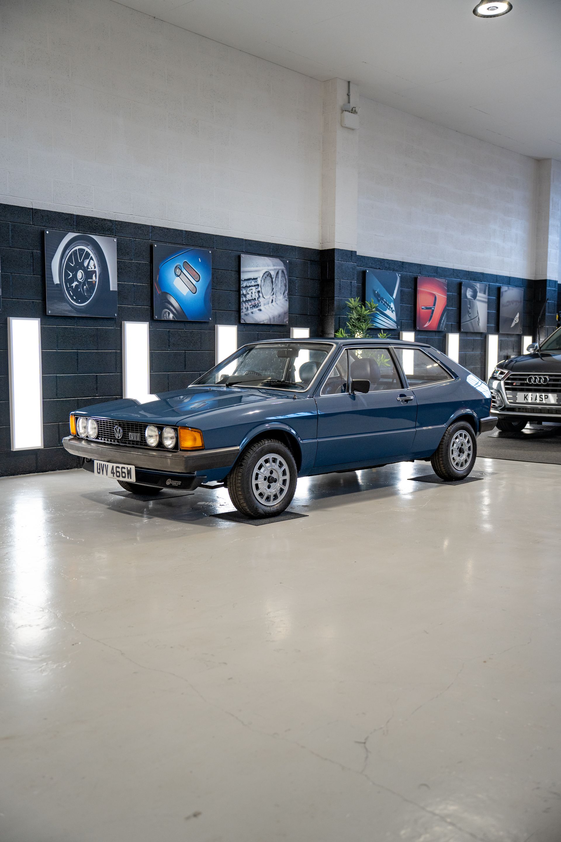 A blue car is parked in a showroom.