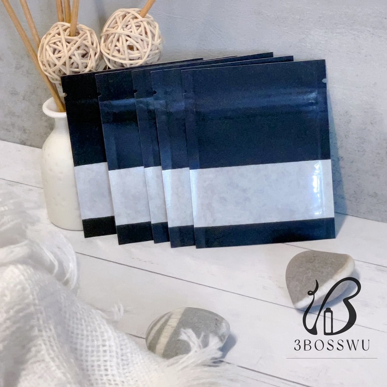 一疊五個帶有透明觀察窗的黑色小密封袋，放在一塊帶流蘇的布上。