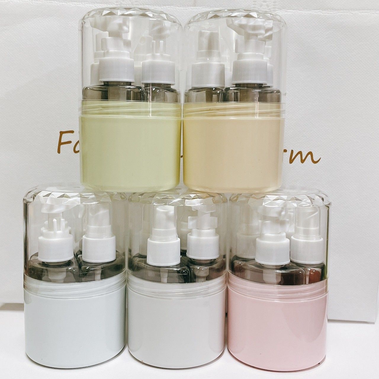 五套色彩鮮豔的旅行裝盥洗用品，配有透明噴霧瓶和實心容器，排列成兩排。