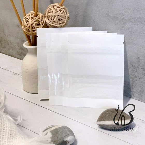 三個空的白色長方形小袋，帶有透明的水平窗口，直立在白色表面上。