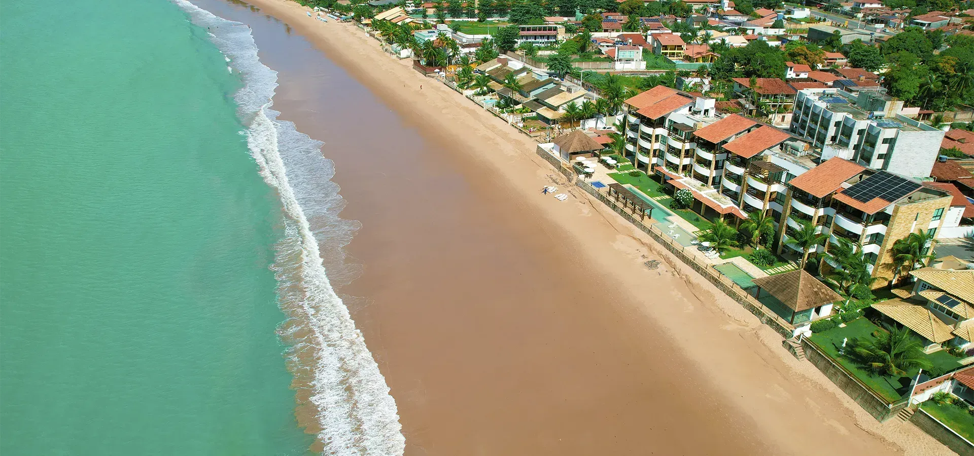 Uma vista aérea de uma praia com edifícios ao fundo