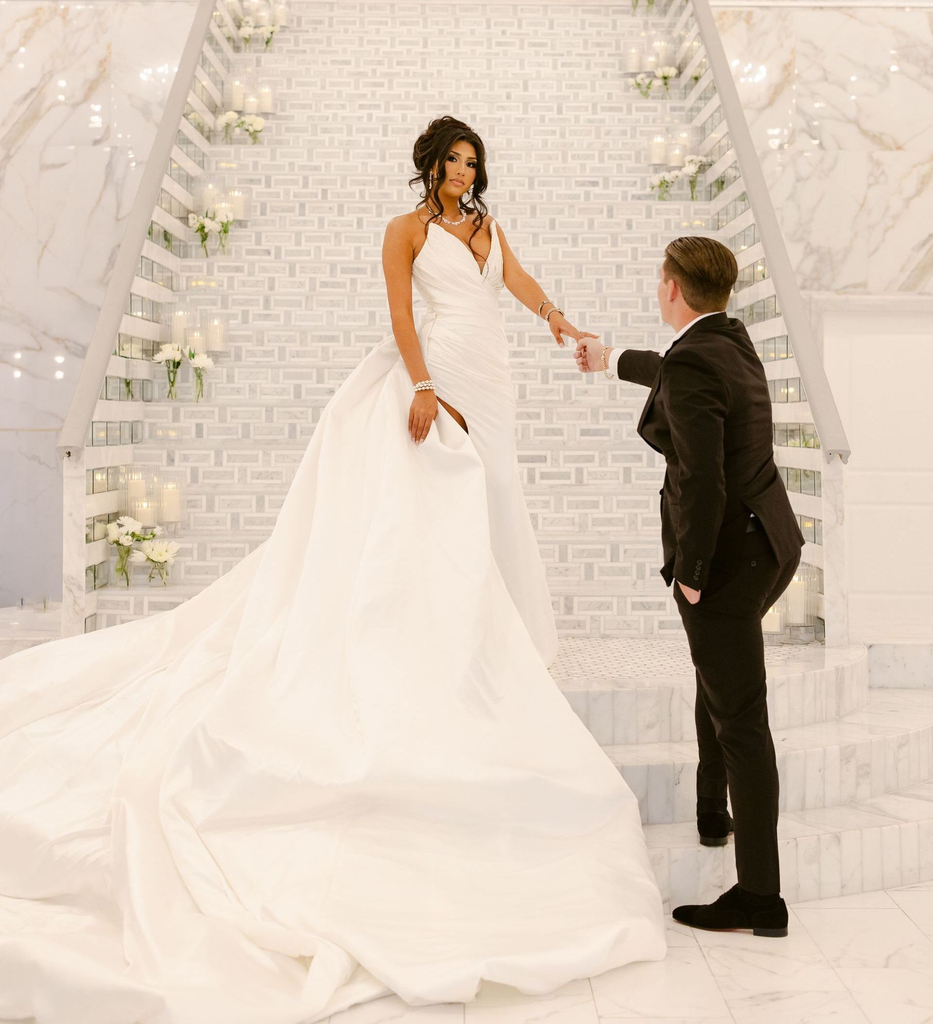 A bride and groom are posing for a picture on a set of stairs.