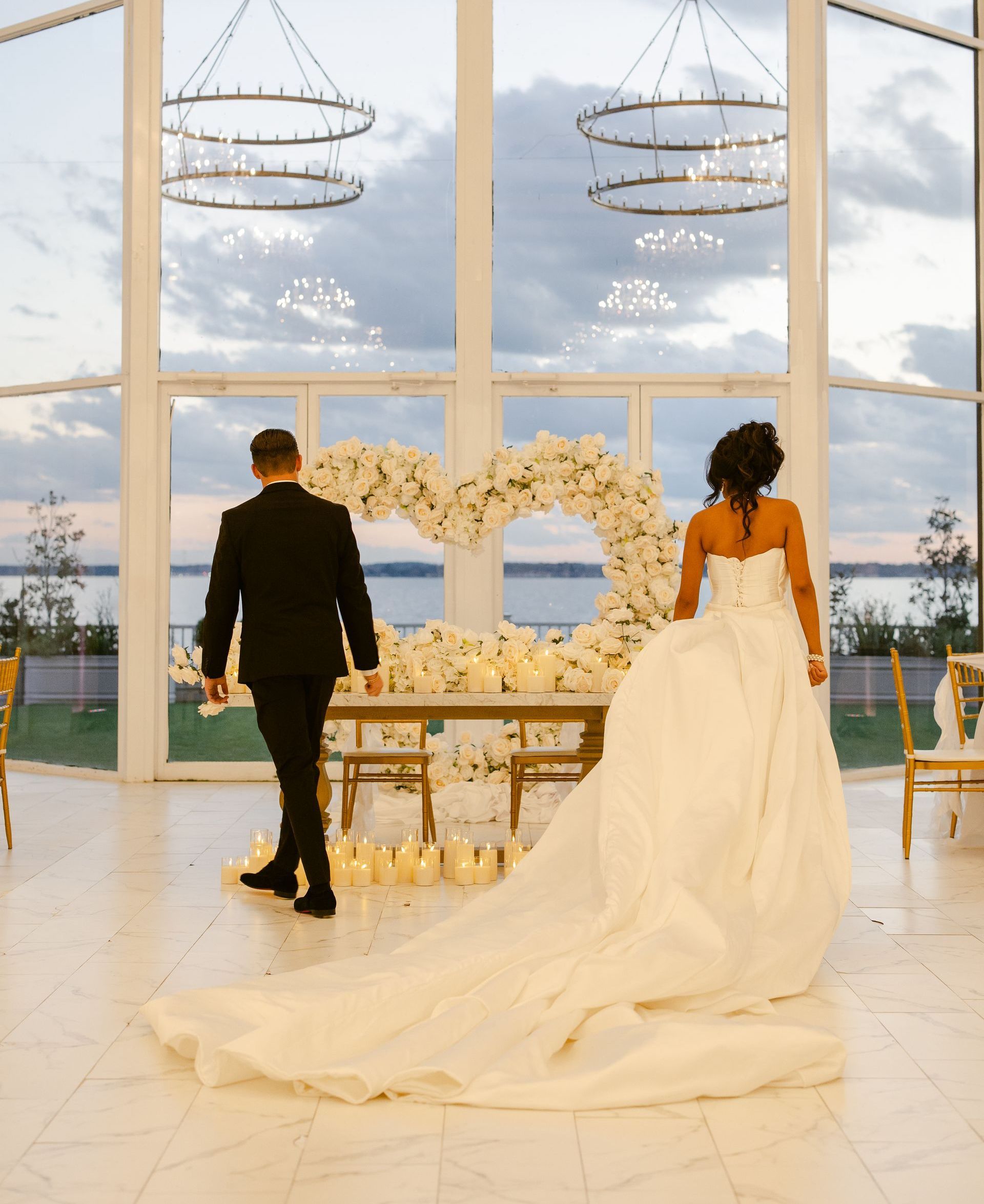 a bride and groom are standing in front of a large window .