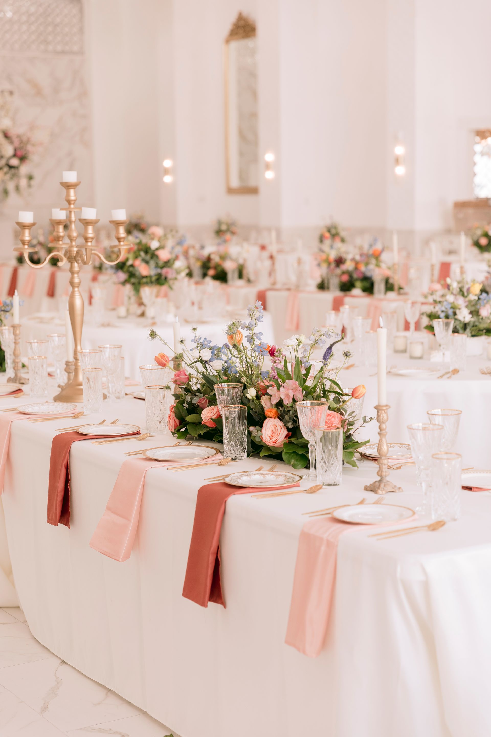 A long table with plates , candles , and flowers on it.