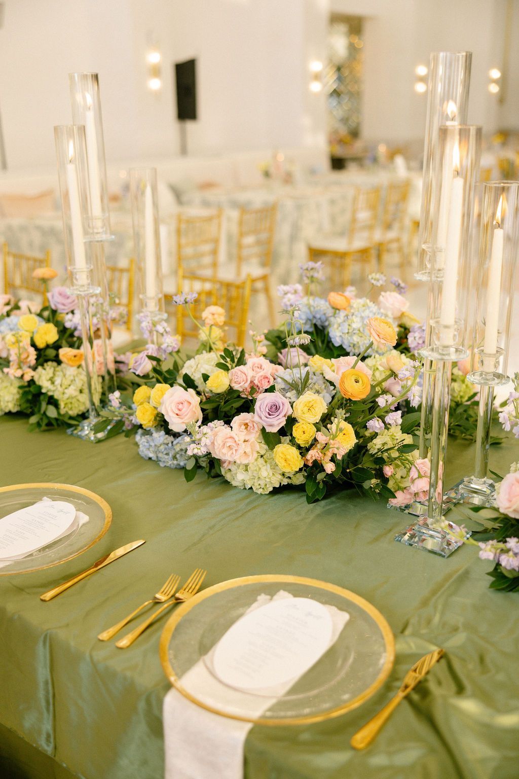 A table with plates , silverware , and flowers on it.