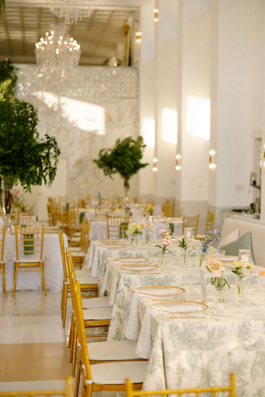 A large room with tables and chairs set up for a wedding reception.