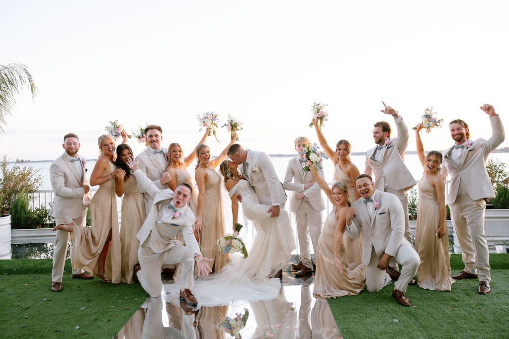 The bride and groom are posing for a picture with their wedding party.