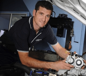 A Man in a Black Shirt is Working on a Car Engine — Mechanical Repairs In Gympie, QLD