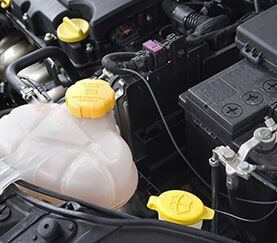 A Close Up of a Car Engine With a Water Tank and a Battery — Mechanical Repairs In Gympie, QLD