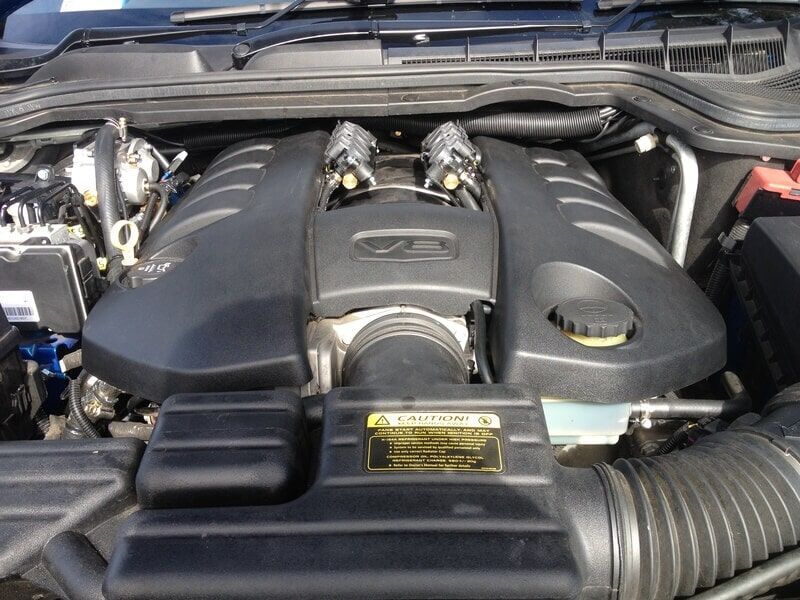 A Close Up of a Car Engine With a Warning Label on It
