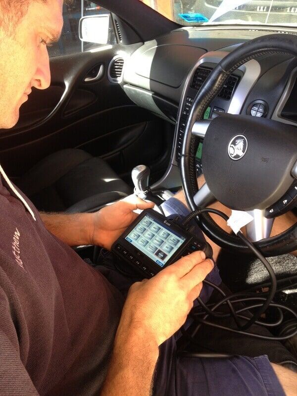 A Man is Sitting in a Car Looking at a Device