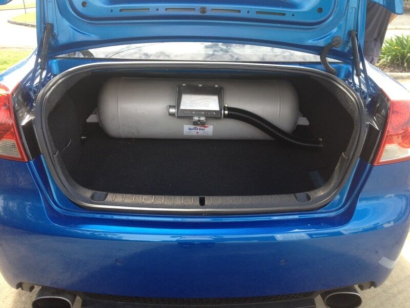 The Trunk of a Blue Car With a Gas Tank in It