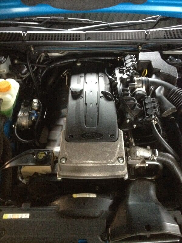 A Close Up of a Car Engine With the Hood Open